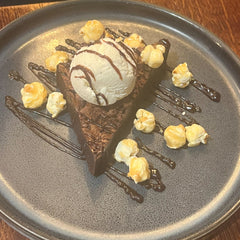 Chocolate brownie topped with vanilla ice cream, chocolate sauce and sweet popcorn at The Hart in Redditch