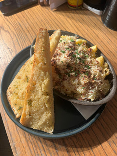 The Hart creamy macaroni cheese topped with grated cheese and herbs, served with garlic bread in Redditch