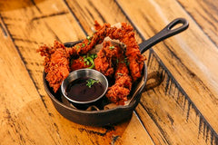 Crispy golden chicken tenders served in a small cast iron skillet with dipping sauce at The Hart in Redditch
