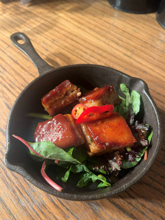 The Hart crispy pork belly bites glazed in sauce with fresh red chilli and mixed leaves in Redditch