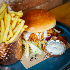 The Hart winter buttermilk fried chicken burger with lettuce, creamy sauce and golden fries in Redditch
