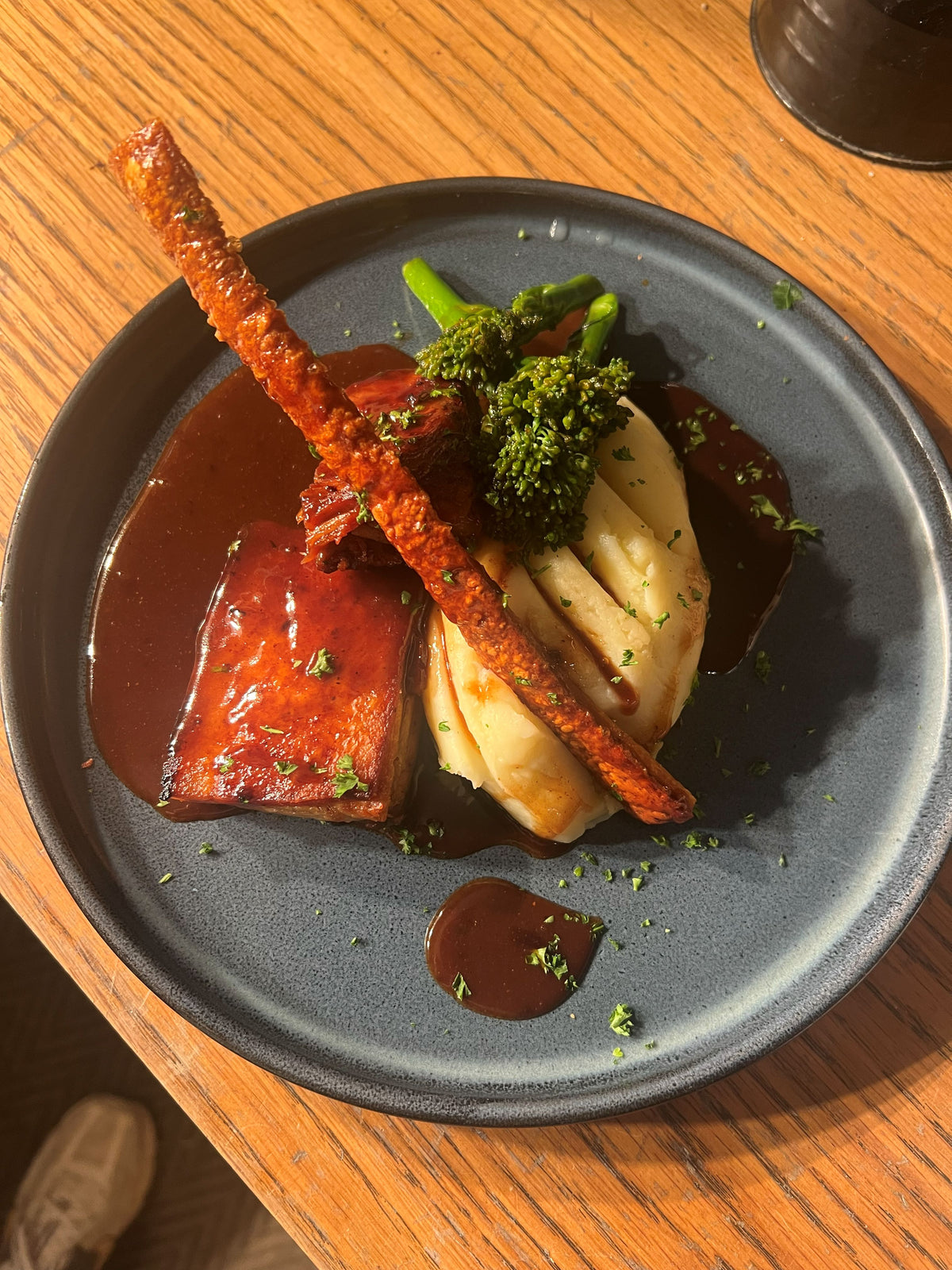 Pork belly with creamy mashed potato, tenderstem broccoli, crispy pork crackling and rich gravy at The Hart in Redditch