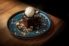 Rich sticky toffee chocolate dessert topped with vanilla ice cream, chocolate sauce and biscuit crumble at The Hart in Redditch