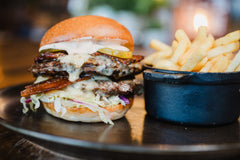The Hart winter double bacon cheeseburger with melted cheese, pickles and golden fries in Redditch